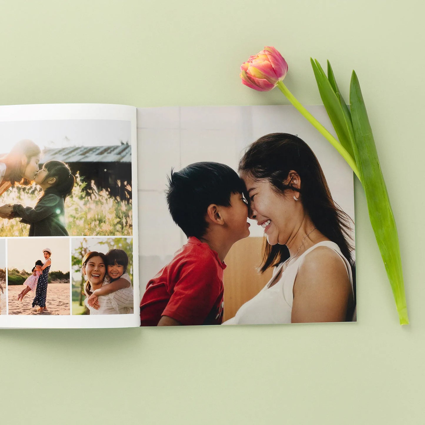 Open softcover photo book featuring a full-page mother and son portrait with smaller family images on the opposite page, styled on a green background with a pink tulip.