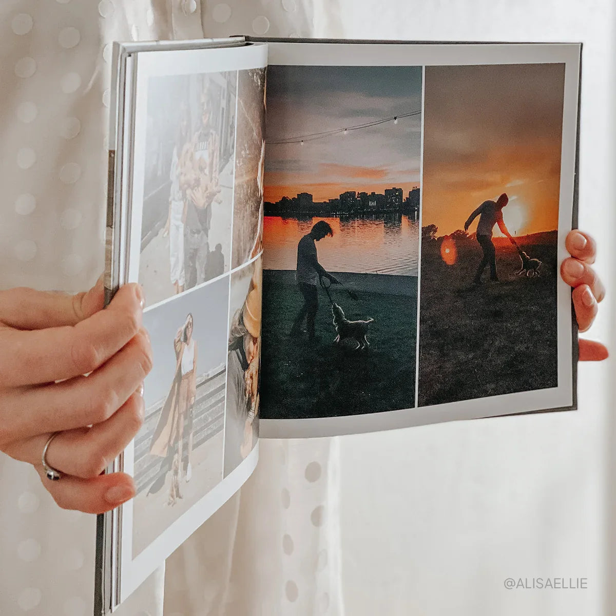Person holding open hardcover photo book displaying multi-image layout with sunset silhouettes and full-bleed photographic pages.