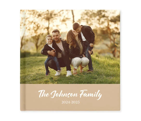 Layflat family photo book cover featuring outdoor portrait and beige title band with family name and year range.