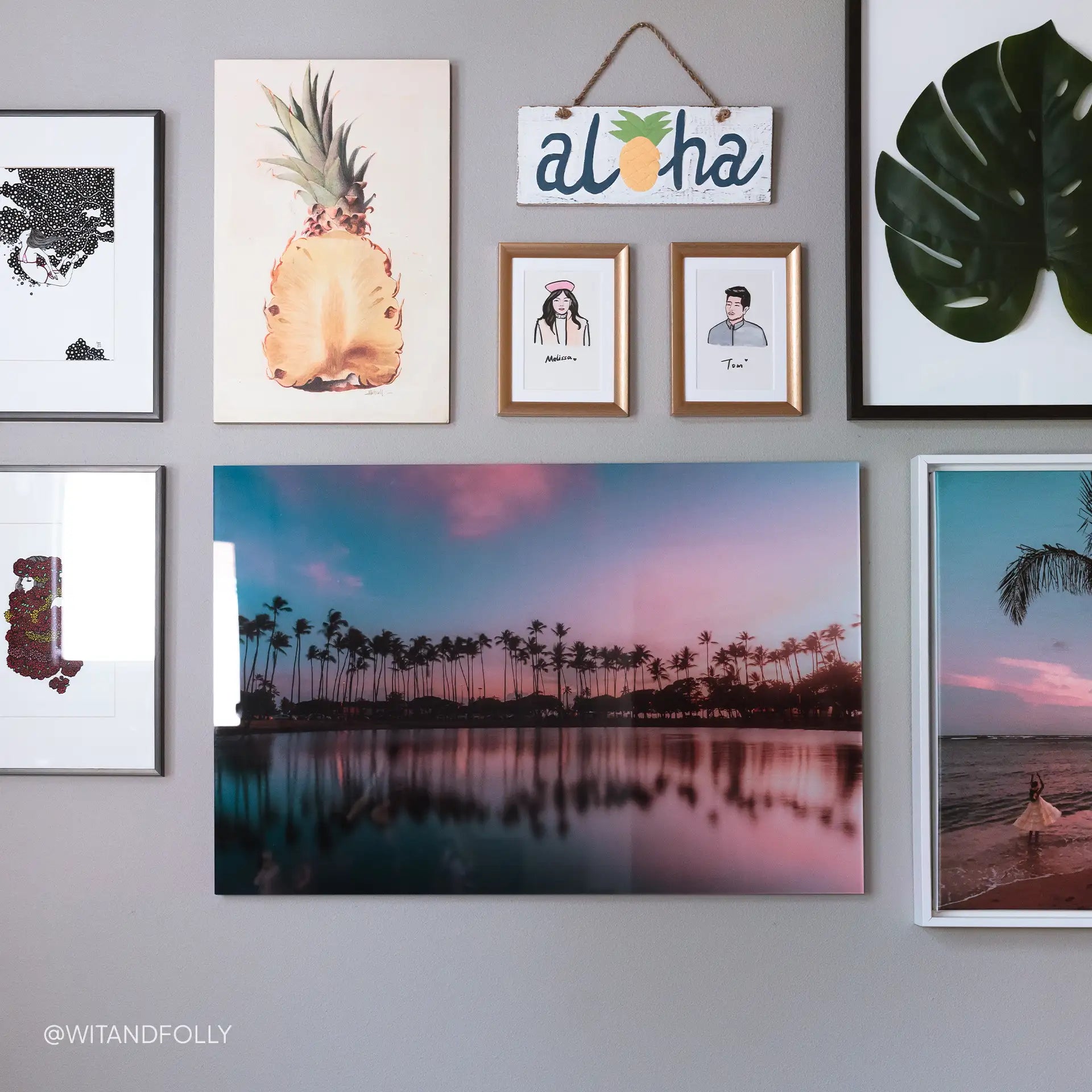 Acrylic wall decor print of palm trees reflected in water at sunset, displayed within a gallery wall arrangement of framed artwork.
