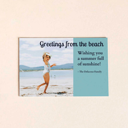 Flat postcard-style card with beach photo of a child and printed message on right side, displayed against a neutral background.