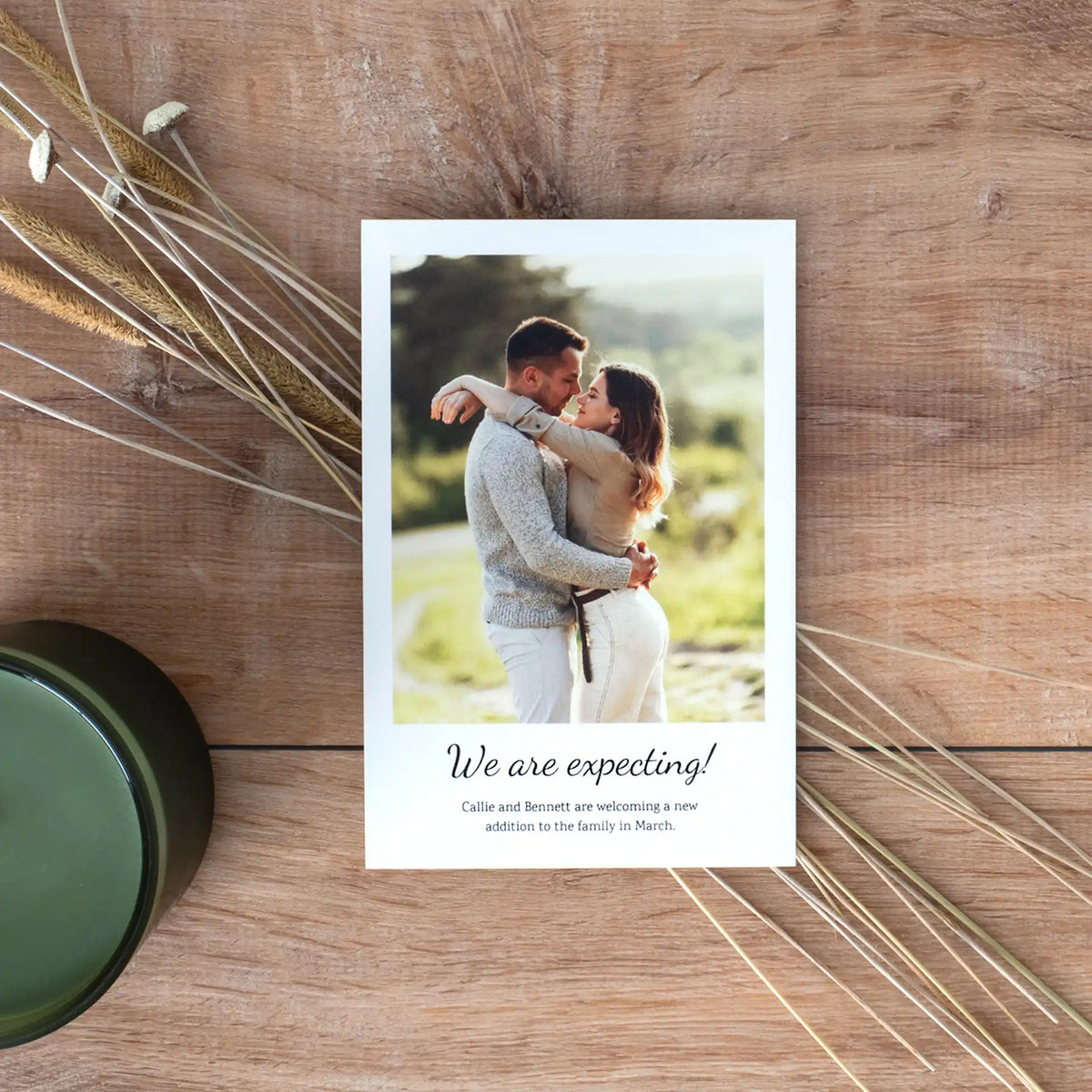 Flat card pregnancy announcement featuring a couple embracing outdoors, with the text 'We are expecting!