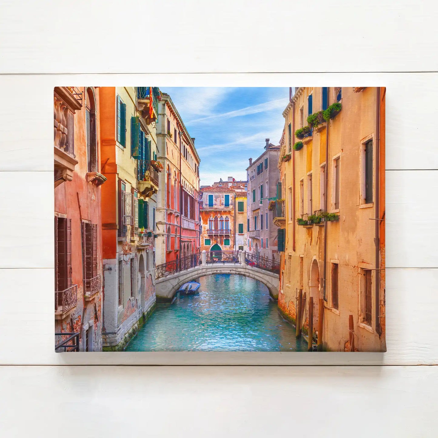 Canvas print of a colorful canal scene with arched bridge, historic buildings, and calm water in a European city setting.