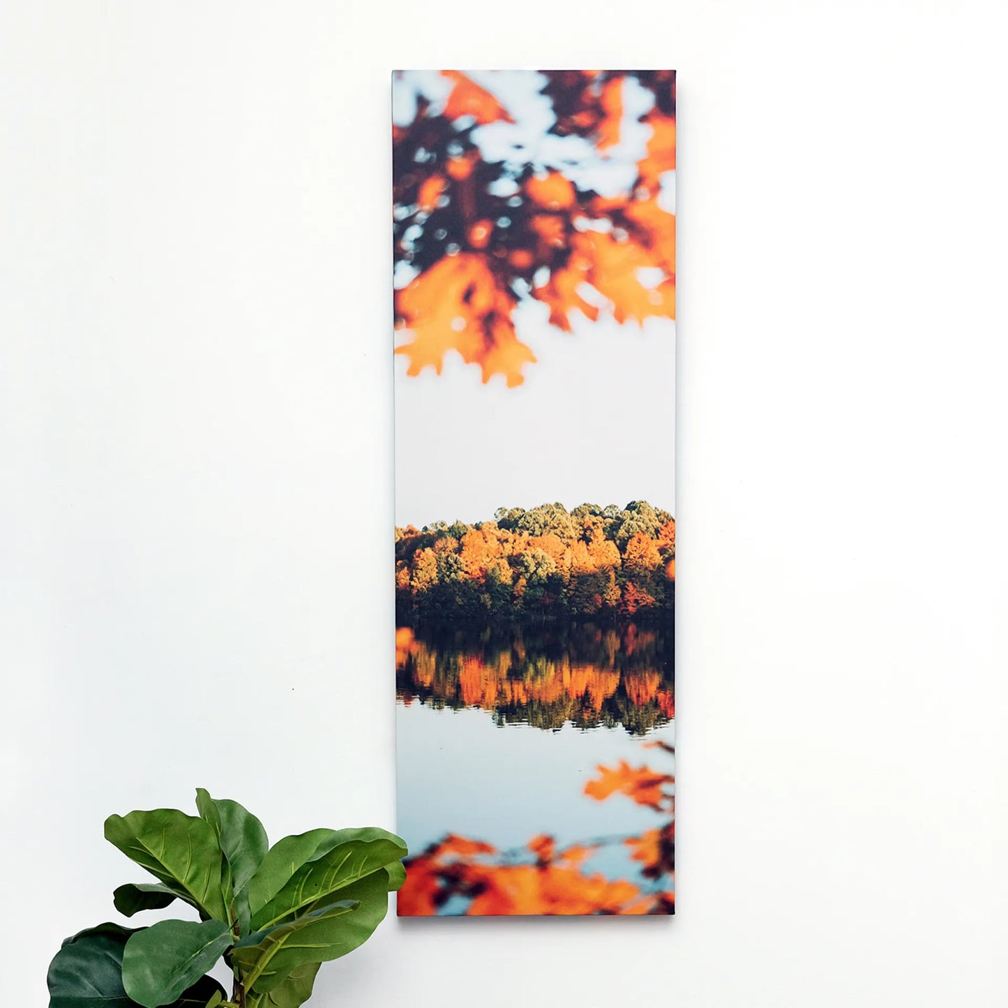 Canvas print showing a vertical autumn landscape with orange leaves, tree-lined shoreline, and reflections on a calm lake.