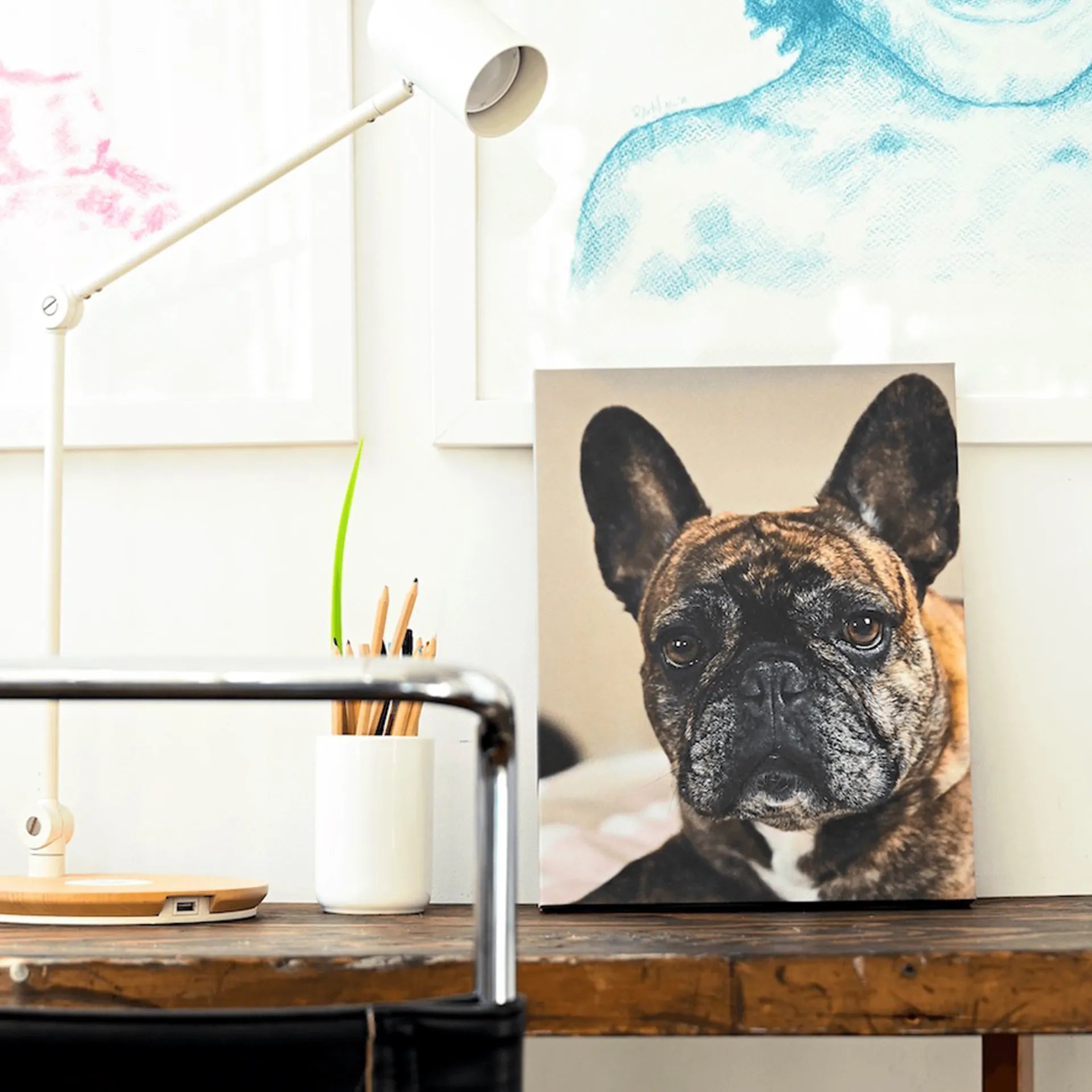 Gallery wrapped canvas featuring a close-up portrait of a French bulldog, styled on a wooden desk with lamp and pencil holder in the background.