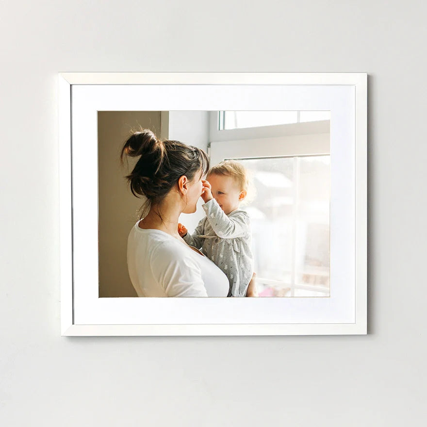 Framed print of a woman and child in a bright room