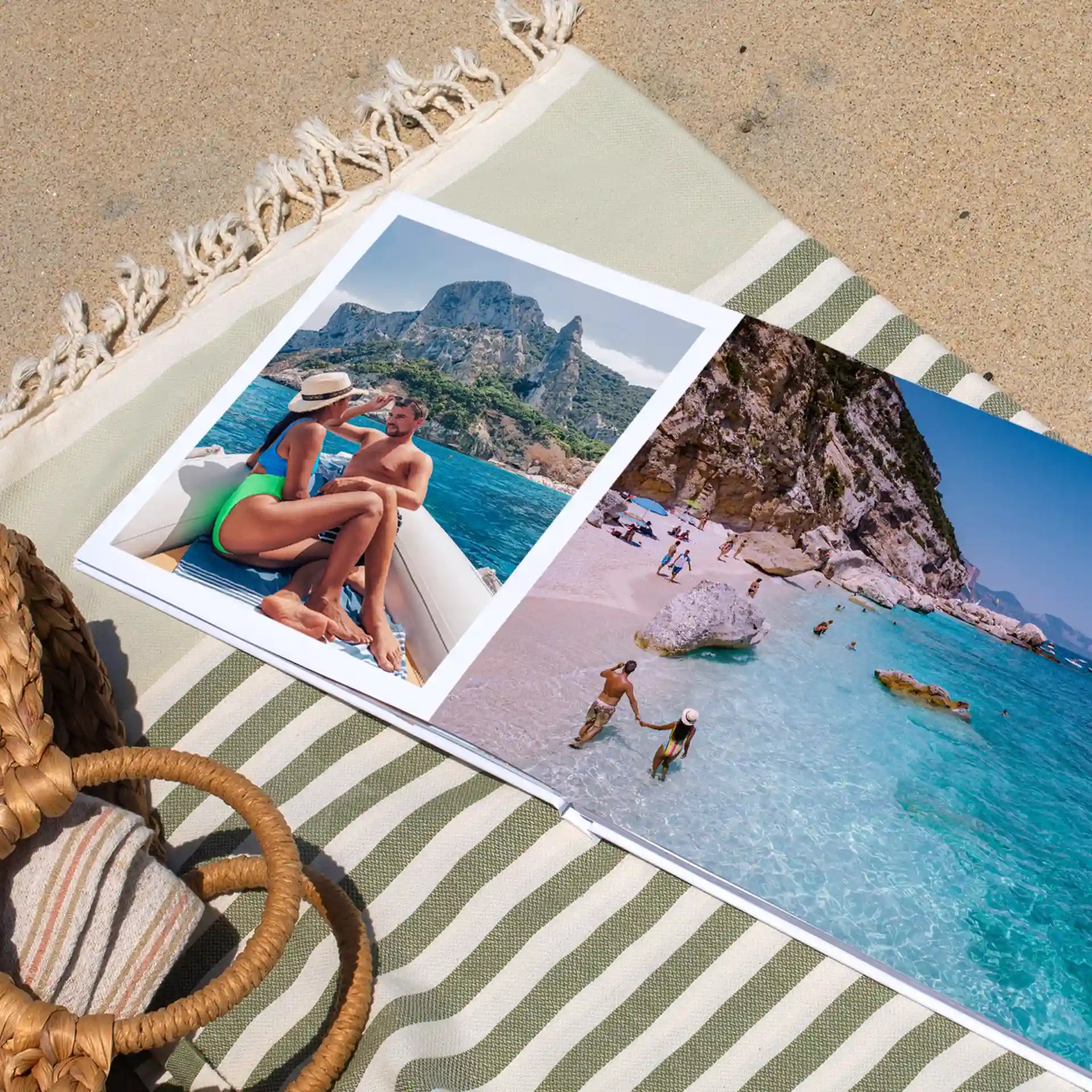 Layflat photo book open on beach towel showing two-page spread with couple boating photo and coastal beach scene in full-bleed layout.