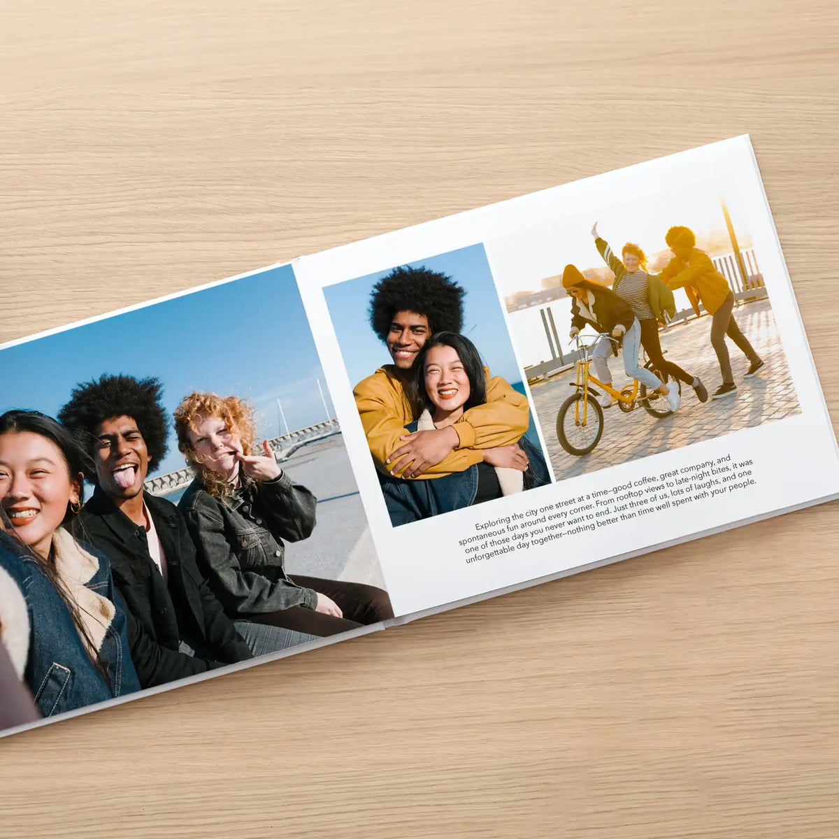 Layflat photo book open to a multi-photo spread of friends laughing together by the water, with a paragraph of caption text.