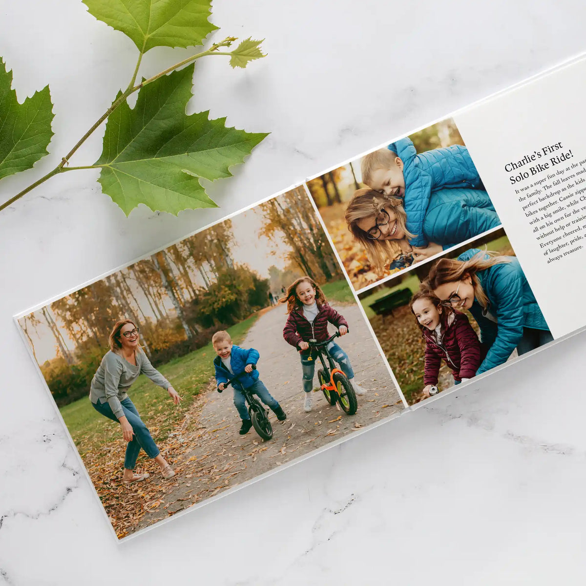 Layflat photo book open to a spread of children riding bikes in an autumn park, with a titled story caption beside the photos.