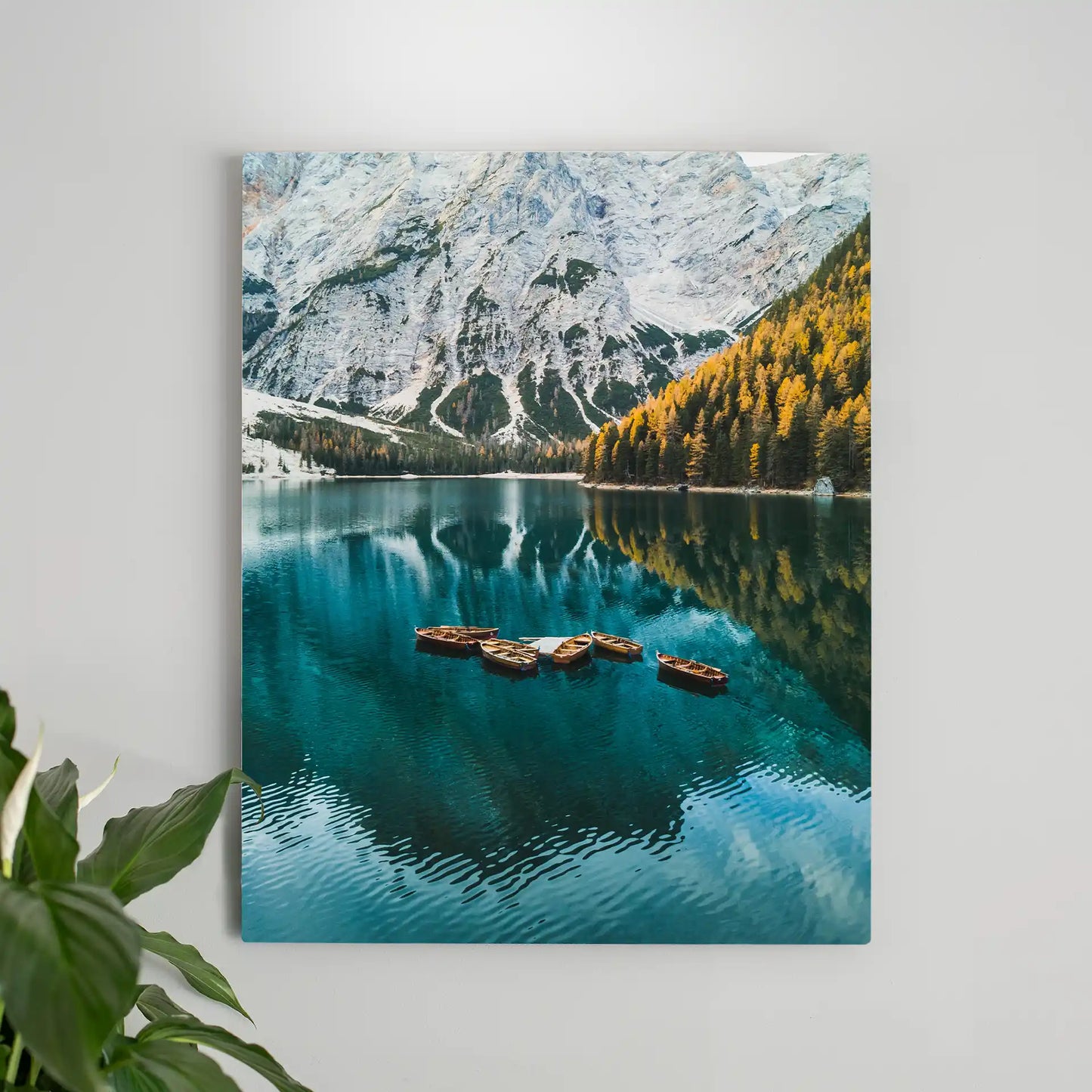 Metal wall decor print of small wooden boats floating on a turquoise lake with mountain and forest reflections.