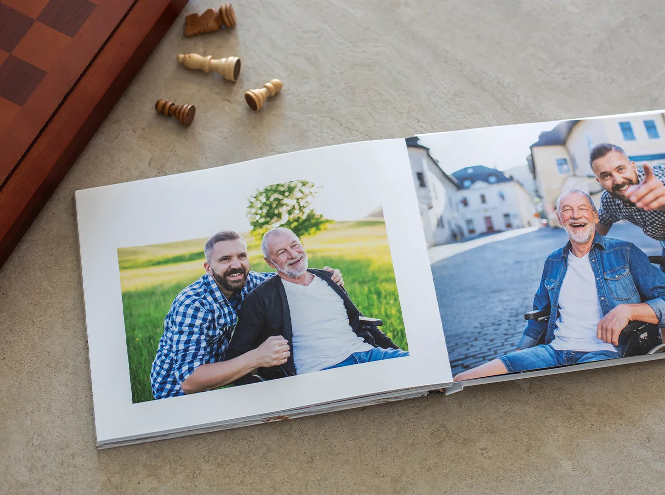 Layflat photo book spread featuring father and son portraits, one in a grassy field and one in a city street with wheelchair
