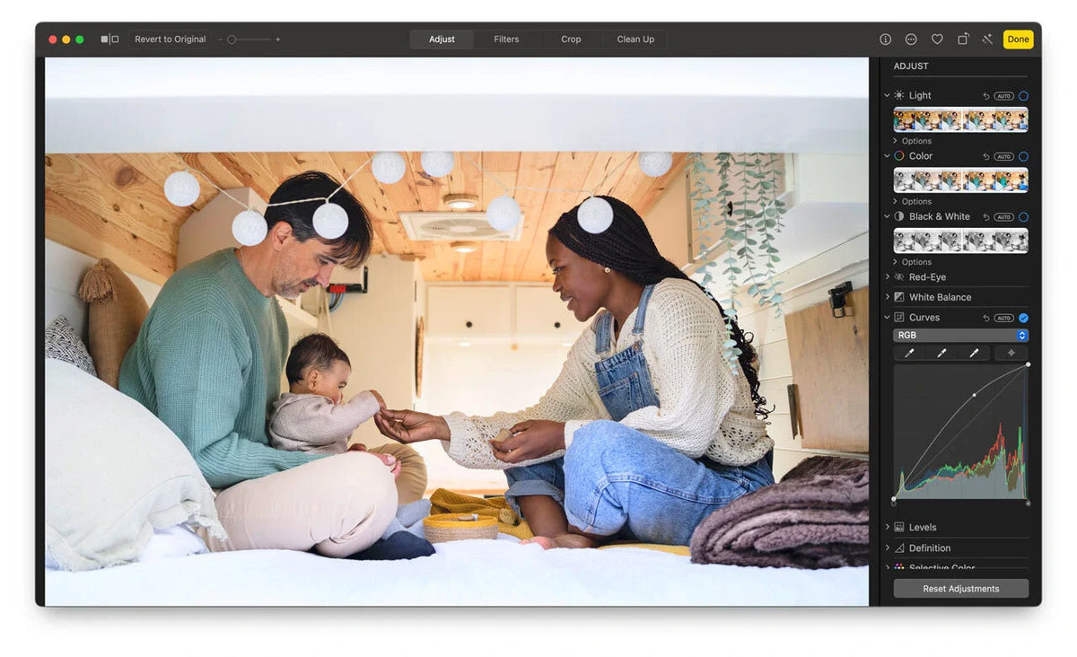 Photo editing interface showing a family inside a camper van, with adjustment tools such as light, color, curves, and white balance displayed in a right-side panel.
