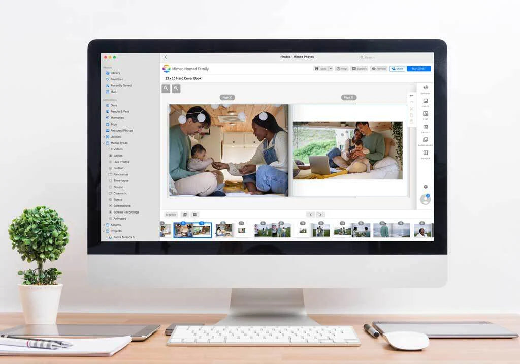 Desktop computer displaying a layflat photo book editor with a family lifestyle spread and page thumbnails along the bottom.