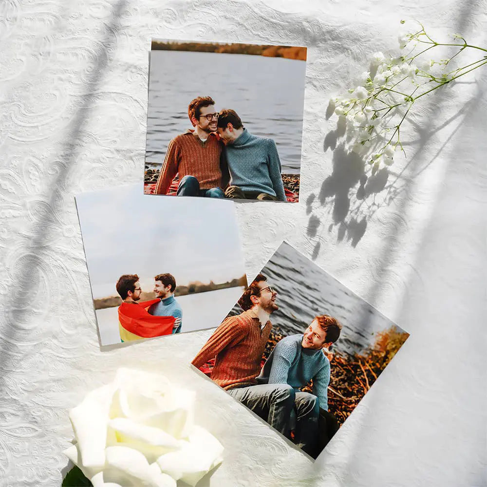 Three square photo prints of a couple on a textured white surface with flowers.