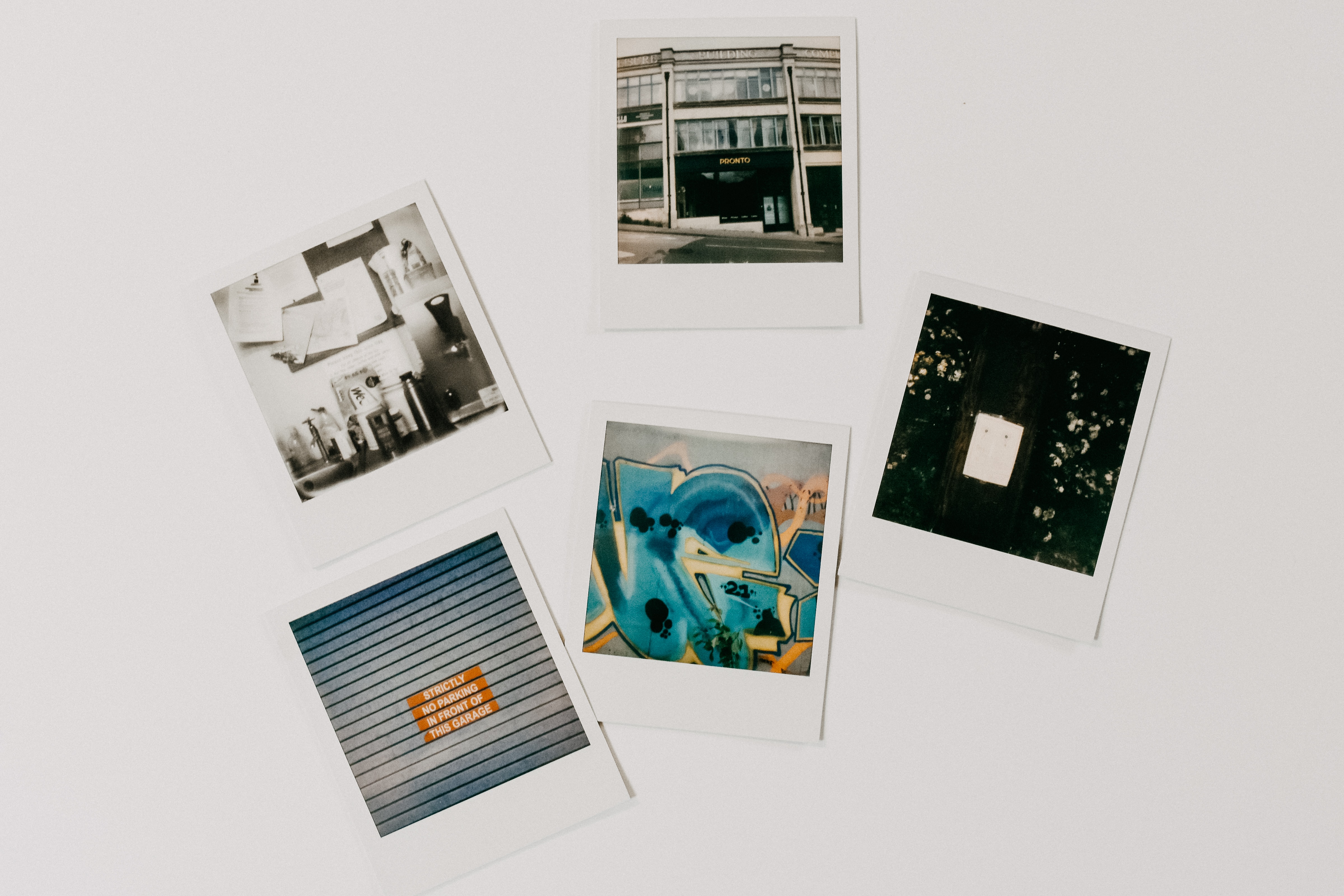 five polaroid pictures displayed on white surface