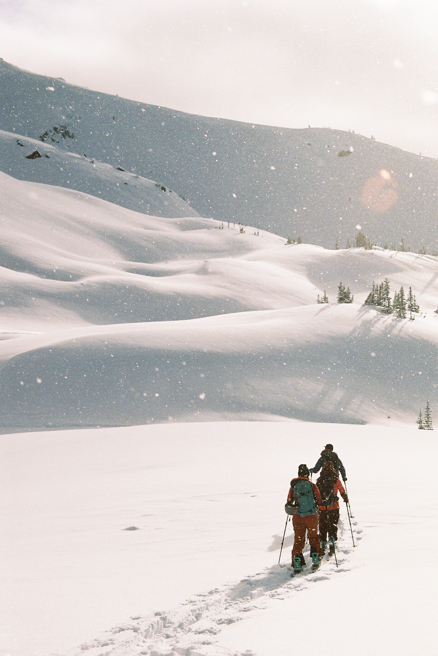 4 skiers walking in the snowy mountains