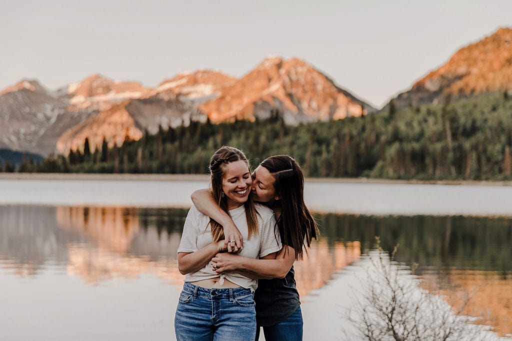 lesbian couple posing in front of mountain landscape