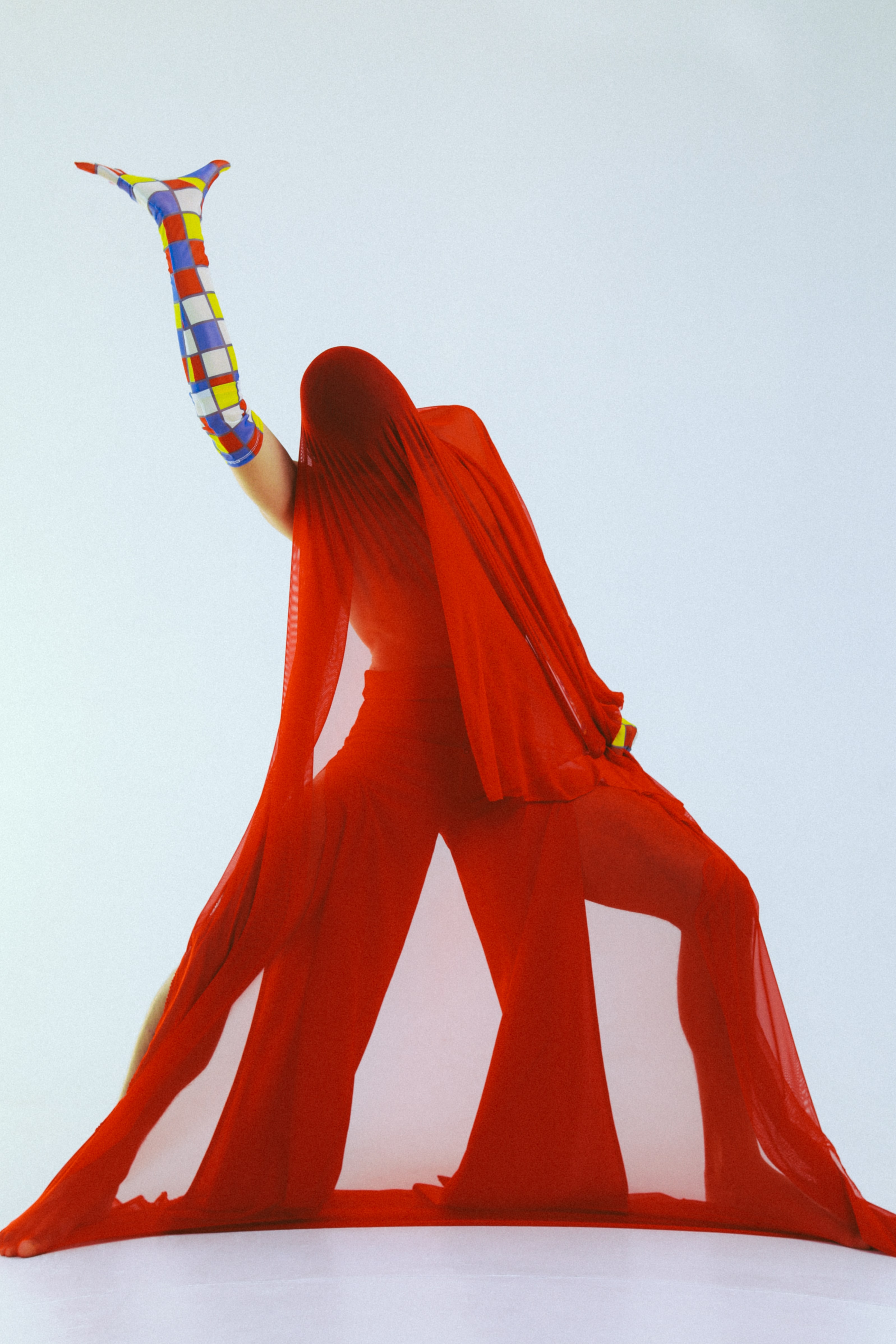 person in red outfit with one colorful glove