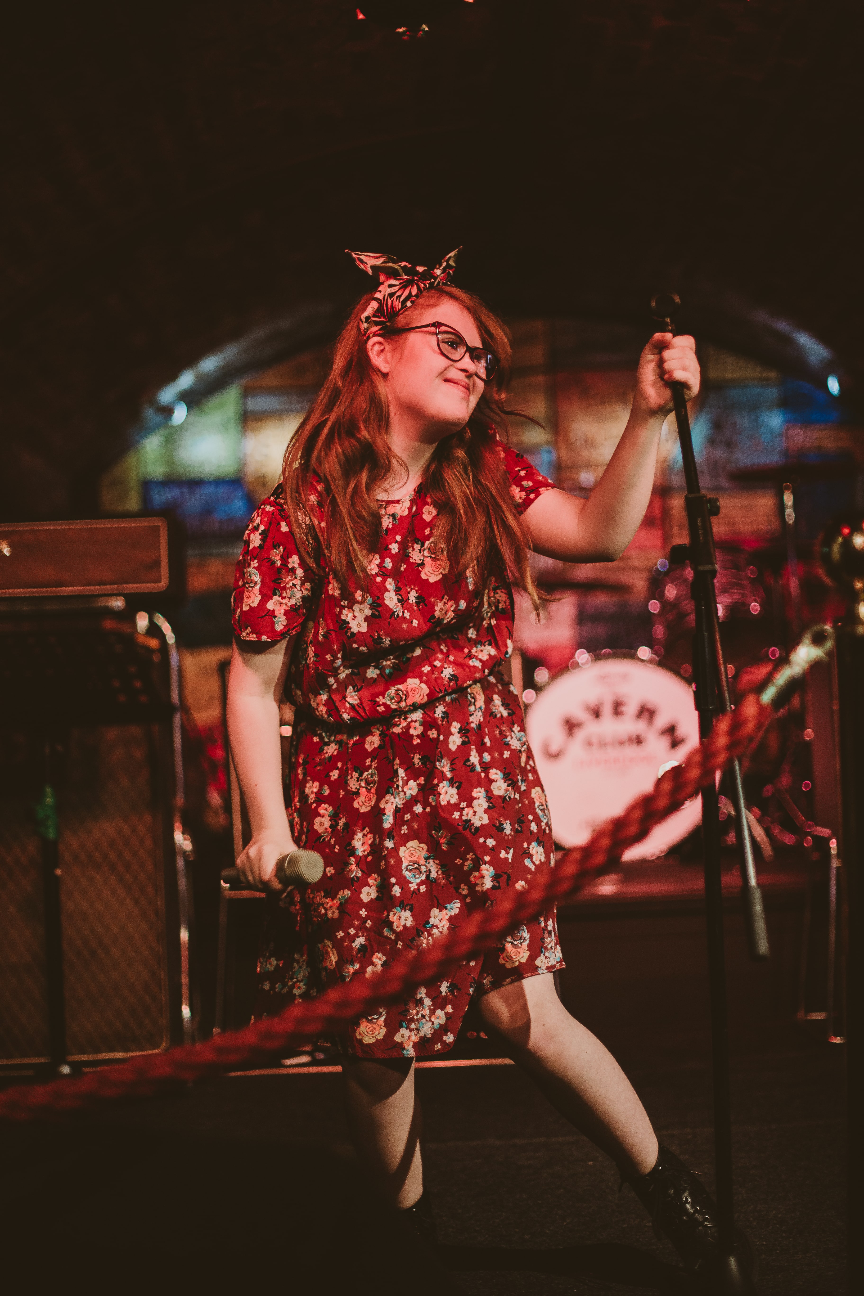 Girl in a dress holding a mic on stage