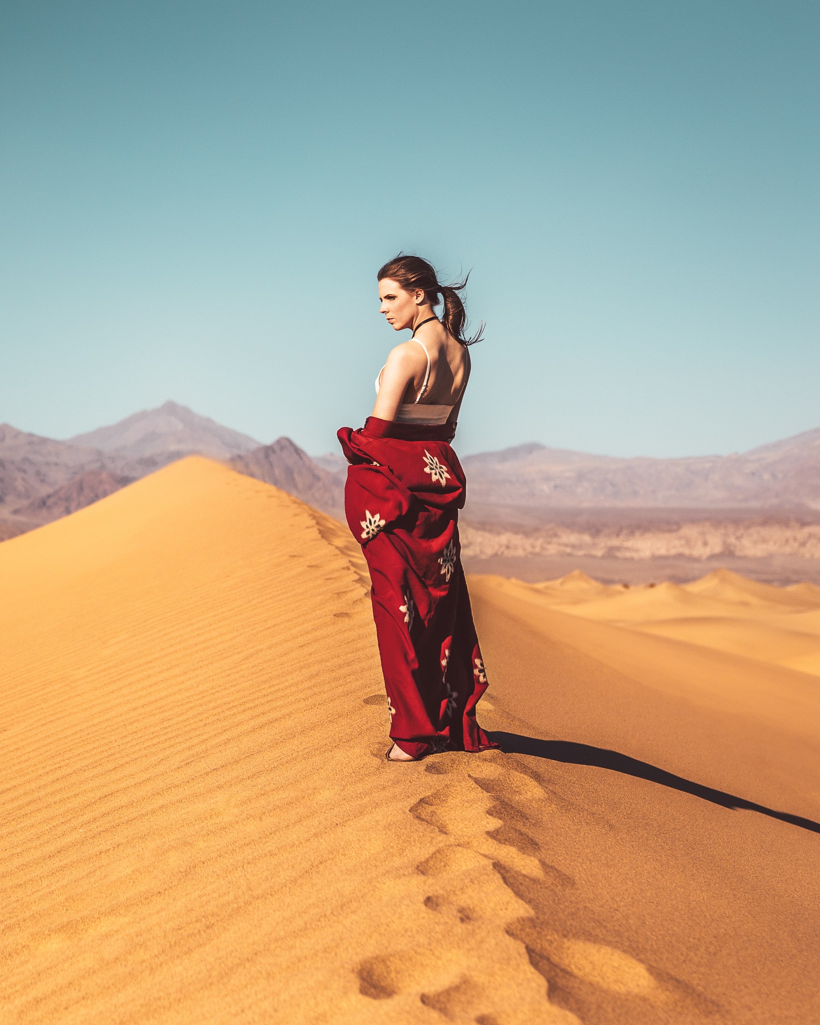 womans standing on top of sandy hill in the desert