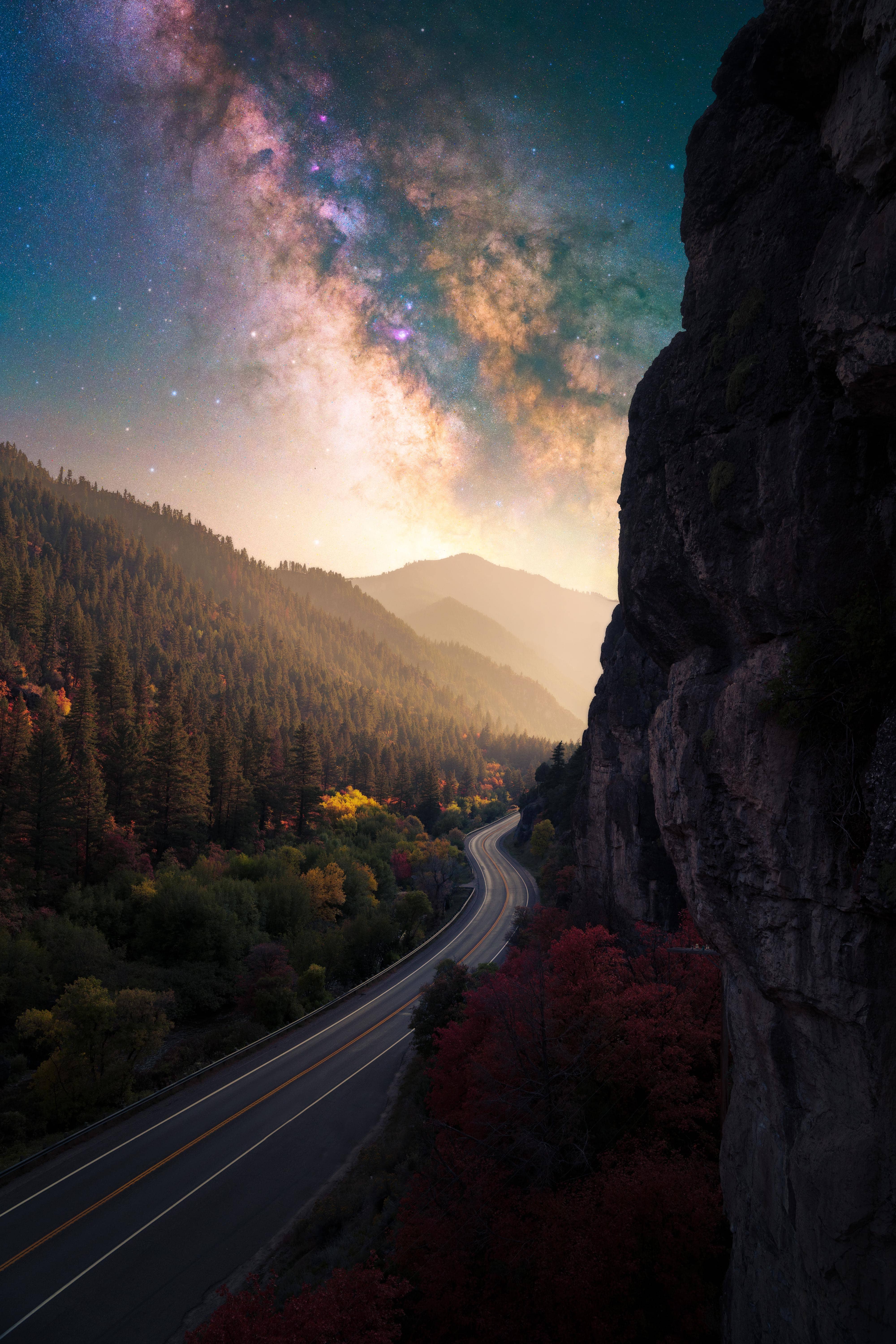Road along a mountain with galaxy in background