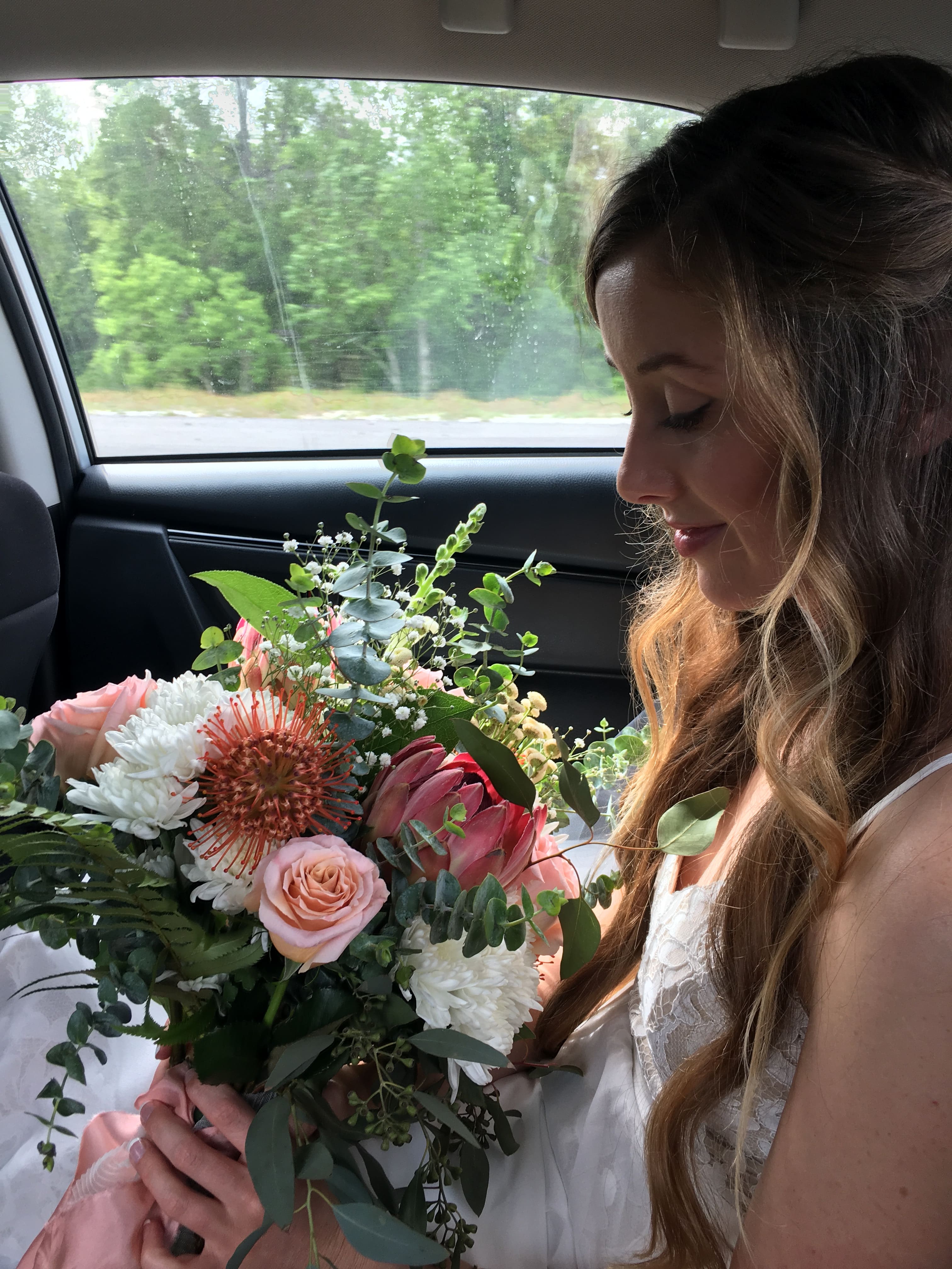 Woman holding bouquet in the car