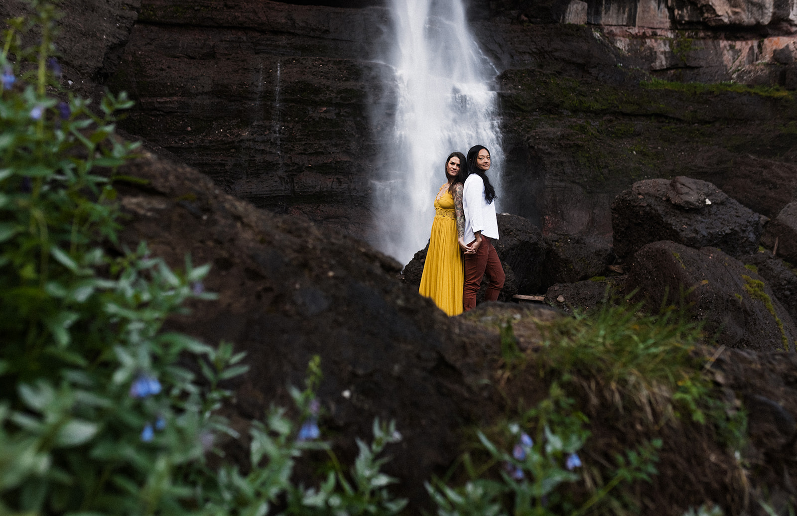 couple standing infront of waterfall
