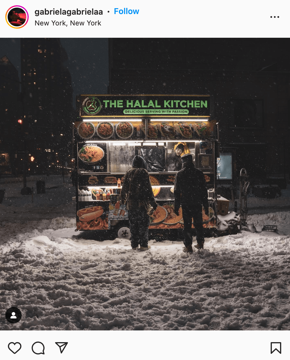 people standing at halal cart while it's snowing