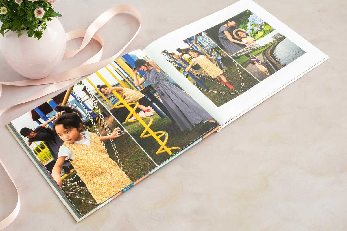 Mother's Day photo book laying open on a table with ribbon and flowers